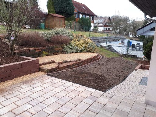 Gartengestaltung mit Pflastersteinen und neu angelegtem Beet