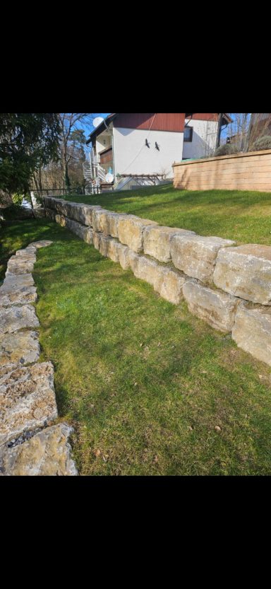Natursteinmauer als Hangbefestigung im Garten